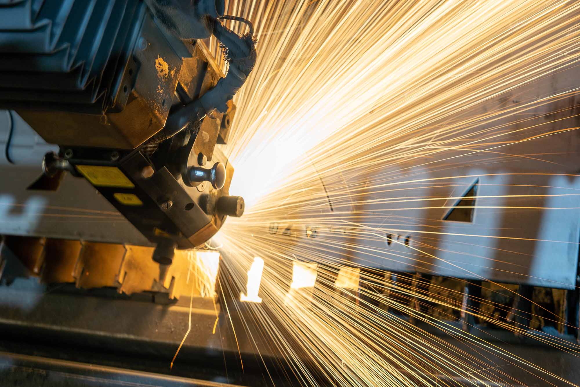a manufacturing scene where a huge amount of sparks are flying away from a contact point.